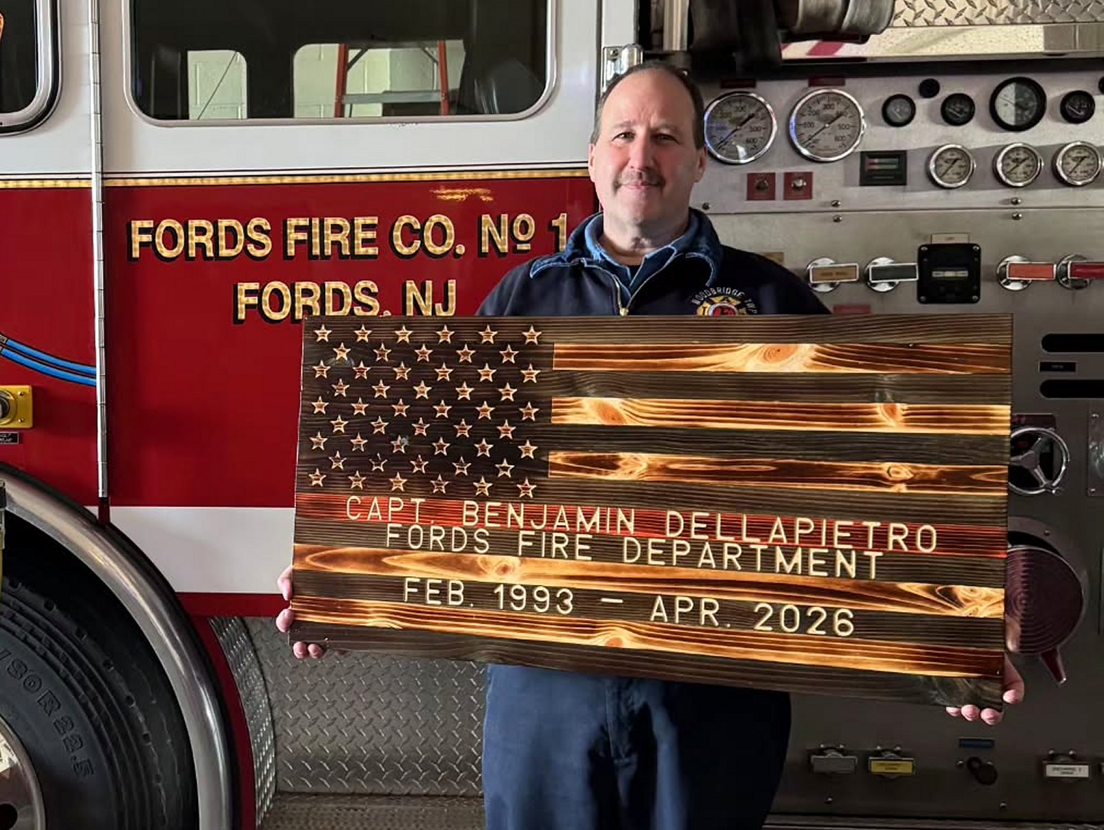 Firefighter at Fords Fire Co. NJ holding his engraved flag